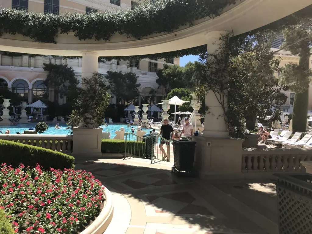 a pool with a large building and a pool with people sitting in it