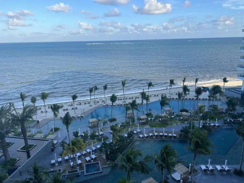 a pool and palm trees by the ocean