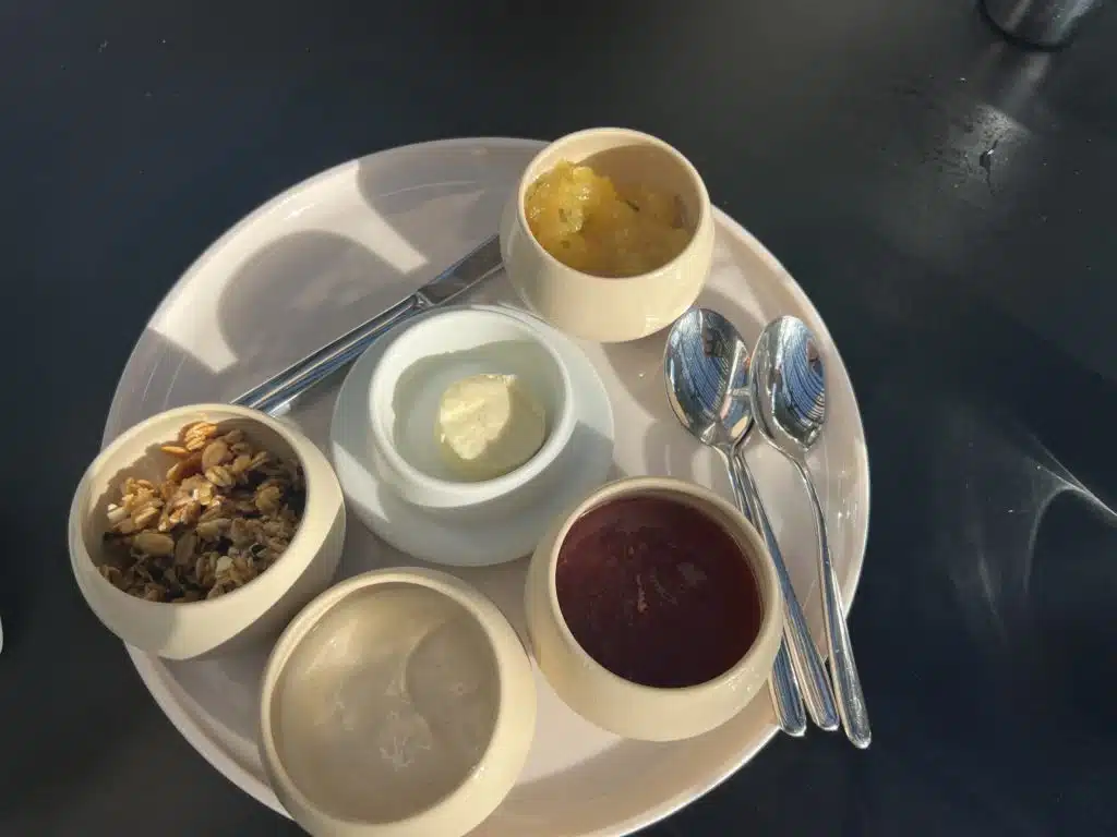 a plate with bowls of food and spoons