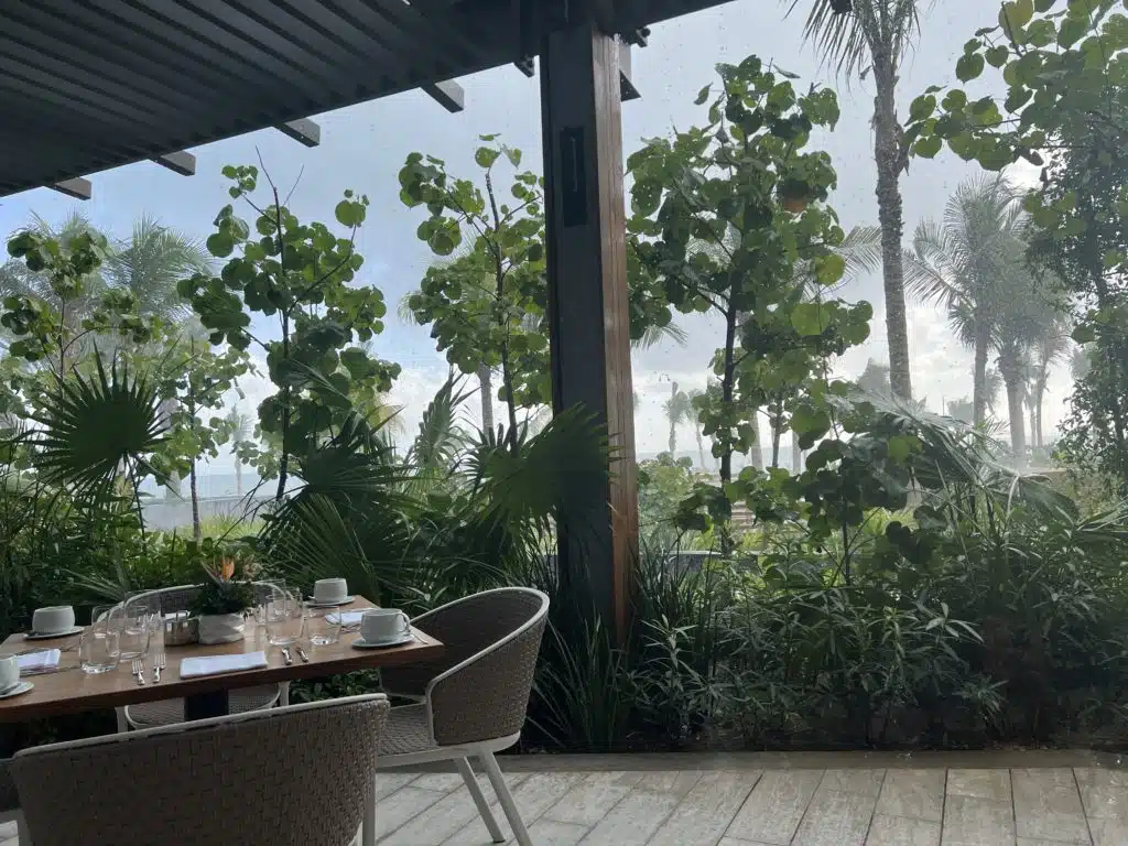 a table and chairs with a view of trees and water