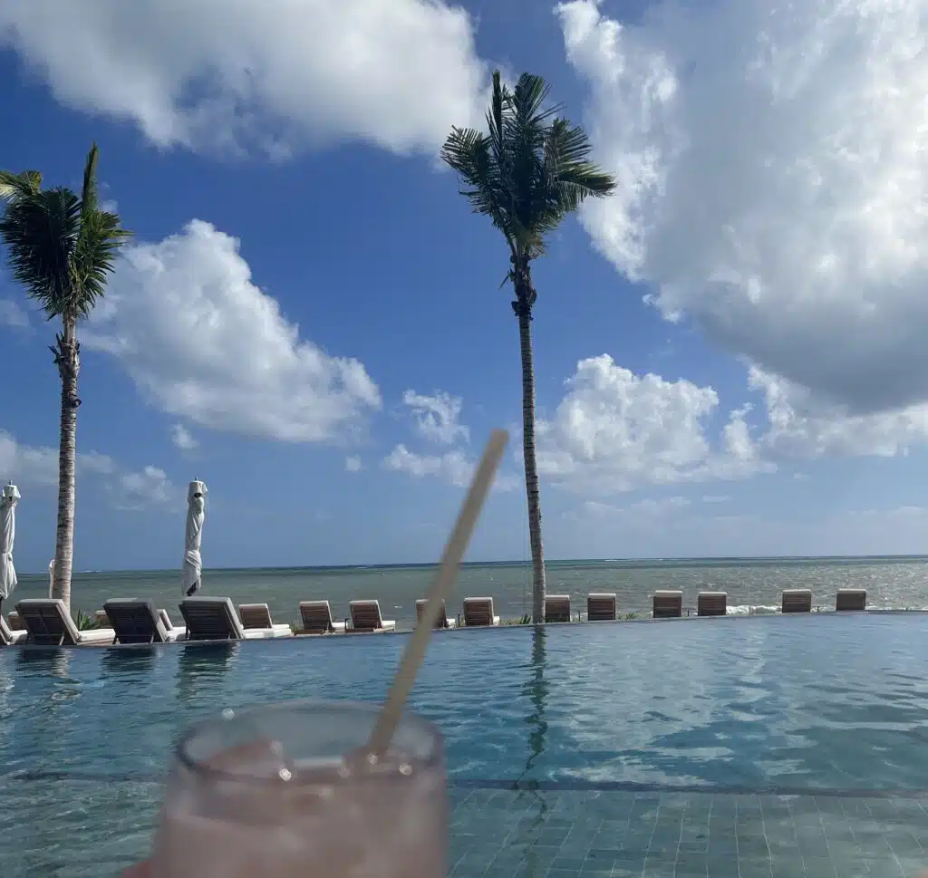 a pool with a drink and palm trees