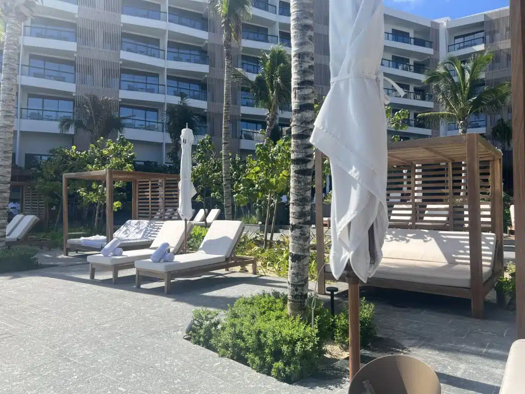 a group of lounge chairs and umbrellas in front of a building